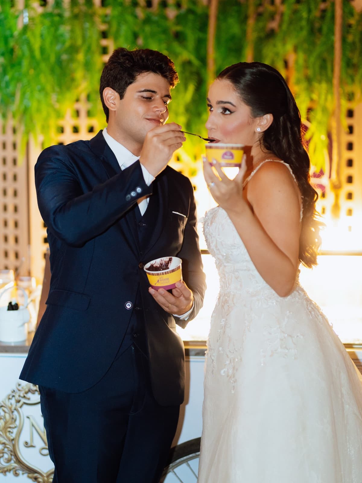 Noivos se servindo de açaí Trevo em copo roxo e amarelo durante o casamento