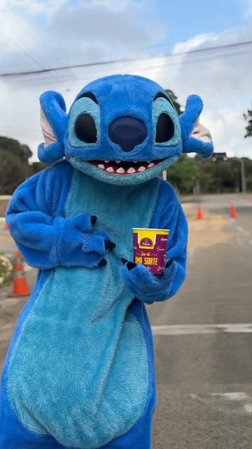 Mascote do Stitch segurando copo de açaí Trevo na Corrida do Stitch